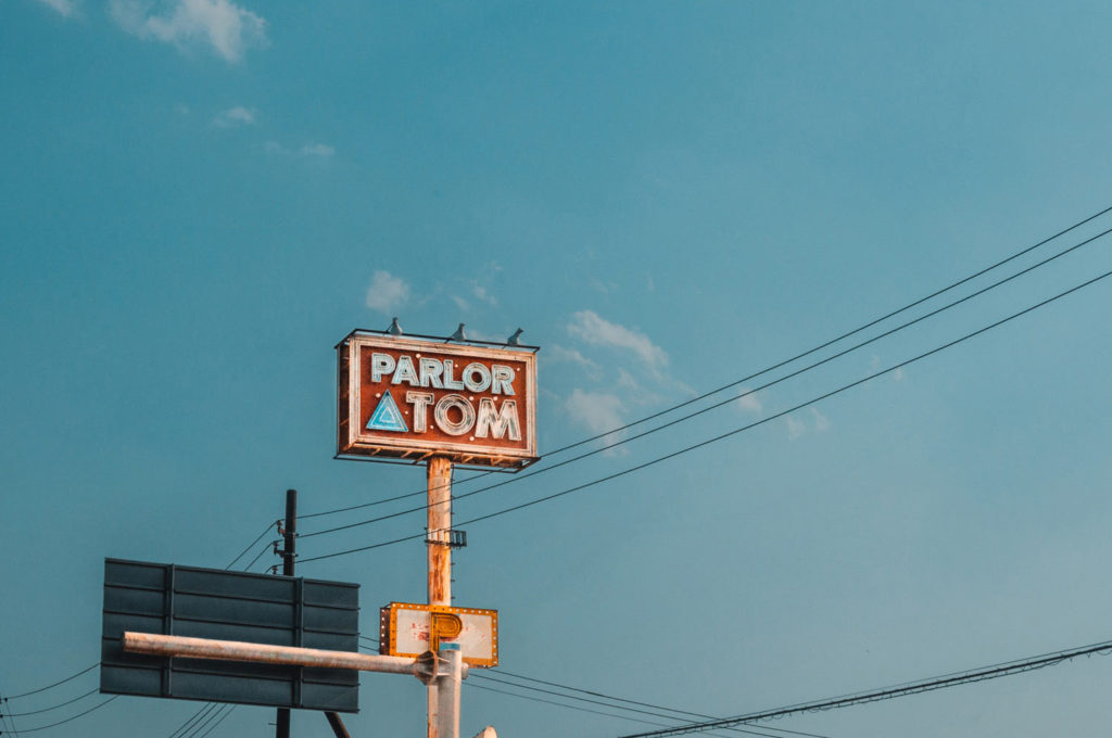 Neon Sign Of Parlor Atom In Fukushima Against A Blue Sky